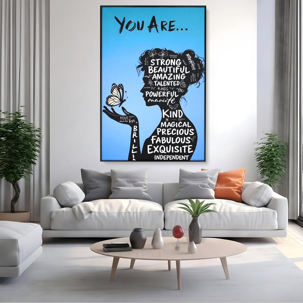 Tablou canvas cu tablou motivational cu portret de femeie si cuvinte, in rama de aluminiu negru, pe perete intr-un living